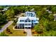 Gorgeous, two-story coastal home with a metal roof, lush landscaping, and a paved driveway on a sunny day at 2870 Ion Ave, Sullivans Island, SC 29482