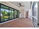 Covered porch featuring wood floors, a ceiling fan, and sliding doors opening to the outdoor living area at 2870 Ion Ave, Sullivans Island, SC 29482