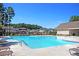Community pool surrounded by lounge chairs and greenery, perfect for relaxation and recreation at 292 Shadybrook Dr, Summerville, SC 29486