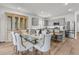 Dining room with a glass table, six chairs, built-in cabinet, with stainless steel refrigerator and hardwood floors at 292 Shadybrook Dr, Summerville, SC 29486