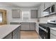 Modern kitchen with stainless steel appliances, ample counter space and grey cabinetry at 292 Shadybrook Dr, Summerville, SC 29486