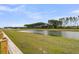 Picturesque view of a calm pond bordered by a grassy lawn and a sturdy wooden fence at 292 Shadybrook Dr, Summerville, SC 29486