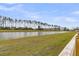Scenic view of a tranquil pond surrounded by green grass and a wooden fence at 292 Shadybrook Dr, Summerville, SC 29486