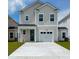 Charming two-story home featuring a well-manicured lawn, attached garage, and neutral siding at 302 Chapman Cir, Goose Creek, SC 29445