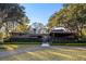 A modern house with a well-manicured lawn, mature trees, and a gravel driveway at 317 Seewee Cir, Mount Pleasant, SC 29464