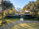 A modern house with a well-manicured lawn, mature trees, and a gravel driveway at 317 Seewee Cir, Mount Pleasant, SC 29464