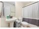 Bathroom with a pedestal sink, a toilet, and a shower with gray and white striped curtain at 317 Whispering Breeze Ln, Summerville, SC 29486