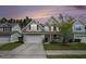 Charming two-story home with a well-maintained lawn, a two-car garage, and a cozy front porch at dusk at 317 Whispering Breeze Ln, Summerville, SC 29486