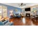 Cozy living room featuring a fireplace, a ceiling fan, hardwood floors, and a comfortable seating area at 317 Whispering Breeze Ln, Summerville, SC 29486