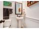 Stylish powder room featuring a pedestal sink, wainscoting, and decorative accents for a clean, modern design at 317 Whispering Breeze Ln, Summerville, SC 29486