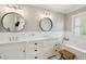 Elegant bathroom featuring double sinks, round mirrors, and a soaking tub with stylish fixtures at 337 Evian Way, Mount Pleasant, SC 29464