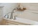 A close-up of the bathtub with a chrome water faucet, soap, and candle holder atop a marble tub surround at 337 Evian Way, Mount Pleasant, SC 29464