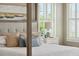 Close up view of four-poster bed, emphasizing pillows, lamps, and décor with plantation shutters at 337 Evian Way, Mount Pleasant, SC 29464