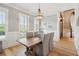 Bright dining room with a rustic wooden table, chandelier, board and batten trim, and hardwood floors at 337 Evian Way, Mount Pleasant, SC 29464