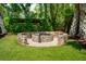 Charming backyard fire pit area with brick surround and lush greenery, creating a cozy outdoor space at 337 Evian Way, Mount Pleasant, SC 29464