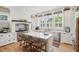 Bright, spacious kitchen features white cabinetry, stainless steel appliances, large central island, and hardwood floors at 337 Evian Way, Mount Pleasant, SC 29464