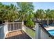 Inviting pool deck with wooden floors and white railings, offering a serene view of the pool and palm trees at 337 Evian Way, Mount Pleasant, SC 29464