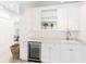 Bar area featuring white cabinets, marble countertops, and a beverage refrigerator at 34 Eugenia Ave, Kiawah Island, SC 29455