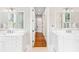 Bright bathroom with dual vanities, white cabinets, and a view into the hallway at 34 Eugenia Ave, Kiawah Island, SC 29455