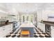 Bright kitchen featuring marble countertops, stainless steel appliances, and an island with seating and black-and-white flooring at 34 Eugenia Ave, Kiawah Island, SC 29455