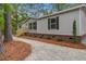 Charming single story home featuring a gravel yard and red brick accents, nestled in a wooded area at 409 Peacock Ln, Summerville, SC 29483