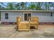 Features an outdoor wooden deck with stairs, contrasting brick detail, and modern siding at 409 Peacock Ln, Summerville, SC 29483