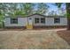 Charming single story home showcasing a gravel yard and wooden steps leading to the front door at 409 Peacock Ln, Summerville, SC 29483