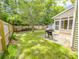 Spacious backyard with a wood fence, patio, grill, sunroom, and well-maintained lawn at 5276 Copley Cir, Summerville, SC 29485