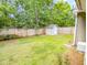 Green backyard featuring a wooden fence, storage shed, and well-maintained lawn at 5276 Copley Cir, Summerville, SC 29485