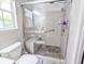 Tiled shower with a built-in seat and safety bar features glass door, overhead, and handheld shower heads at 5276 Copley Cir, Summerville, SC 29485