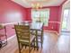 Dining room area with pink walls, trim detail, chandelier, and natural light at 5276 Copley Cir, Summerville, SC 29485
