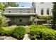 A beautiful backyard with manicured green lawns, a stone path, lush shrubbery, and a cottage-style home exterior at 6 Judith St, Charleston, SC 29403
