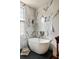 Elegant white bathtub beneath a window with white marble surround and floors at 6 Judith St, Charleston, SC 29403