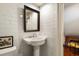 This powder room features white subway tile, a pedestal sink, and view to an adjacent office at 6 Judith St, Charleston, SC 29403
