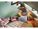 An attic bedroom features wood flooring, light green walls, comfortable armchairs, and wood beam architecture at 6 Judith St, Charleston, SC 29403