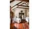 Bedroom features exposed beams, fireplace, chaise lounge, and wood floors with rug at 6 Judith St, Charleston, SC 29403