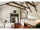 Bedroom features exposed beams, fireplace, chaise lounge, four poster bed and wood floors with rug at 6 Judith St, Charleston, SC 29403