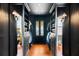 Walk-in closet with custom shelving, drawers, mirrored doors and dark gray walls at 6 Judith St, Charleston, SC 29403