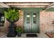 The red brick front entrance has an antique fern planter and traditional sconces at 6 Judith St, Charleston, SC 29403