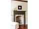 Close up of the fireplace with brick surround and black mantle, flowers and portrait on top at 6 Judith St, Charleston, SC 29403