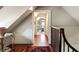 A hallway features wood flooring, stairs with wood banister, and a view into an office with exercise equipment at 6 Judith St, Charleston, SC 29403