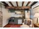 This kitchenette has a refrigerator, stove, vent, sink and decorative art, illuminated by beams of natural light at 6 Judith St, Charleston, SC 29403