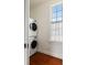 Bright laundry room with stacked washer and dryer, wood floors and a window at 6 Judith St, Charleston, SC 29403