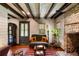 A comfy living room with a brick fireplace, wooden floors, exposed wood beam ceilings, and an eclectic furniture style at 6 Judith St, Charleston, SC 29403