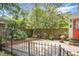 Charming backyard featuring a brick-paved area, wooden fencing, mature trees, and a colorful garden at 7 Chadwick Dr # A, Charleston, SC 29407