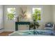 Bright bedroom featuring two large windows, modern decor, and tranquil views of outside greenery at 7 Chadwick Dr # A, Charleston, SC 29407