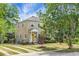 Two-story home with yellow brick exterior and a covered front porch surrounded by beautiful, mature trees at 7 Chadwick Dr # A, Charleston, SC 29407