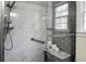 Detailed view of the shower area with marble tile walls, a built-in seat, and modern shower fixtures at 7 Chadwick Dr # A, Charleston, SC 29407