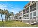 Back of condos with screened-in porches that overlook a spacious grassy area and palm trees at 74 Mariners Cay Dr, Folly Beach, SC 29439
