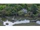 Stunning aerial shot of coastal estate, highlighting the home's proximity to lush greenery and private boat dock at 8374 Chisolm Plantation Rd, Edisto Island, SC 29438